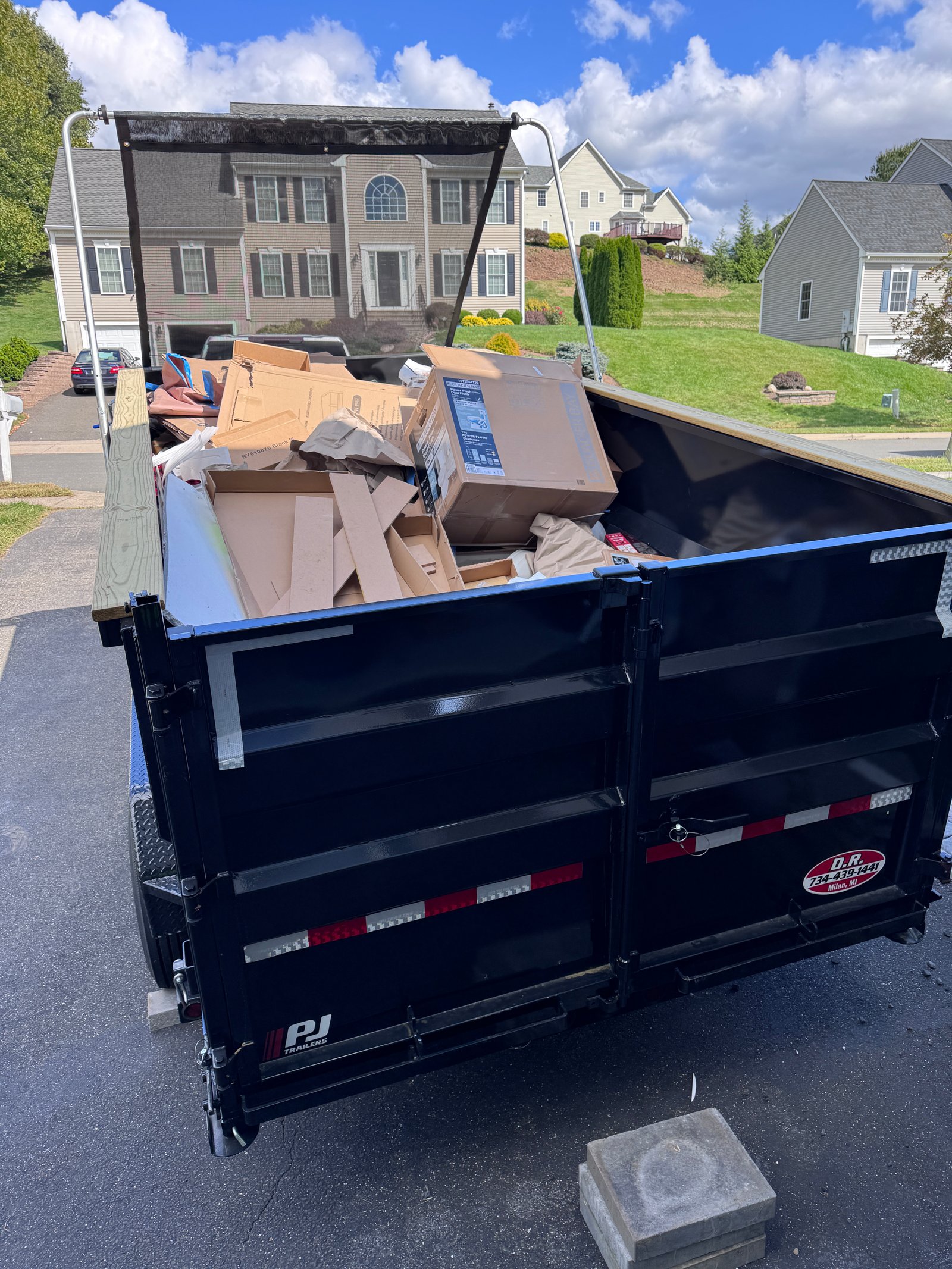 Dump trailer loaded with cardboard and debris during a property cleanout job